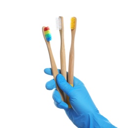 Photo of Dentist holding wooden toothbrushes on white background
