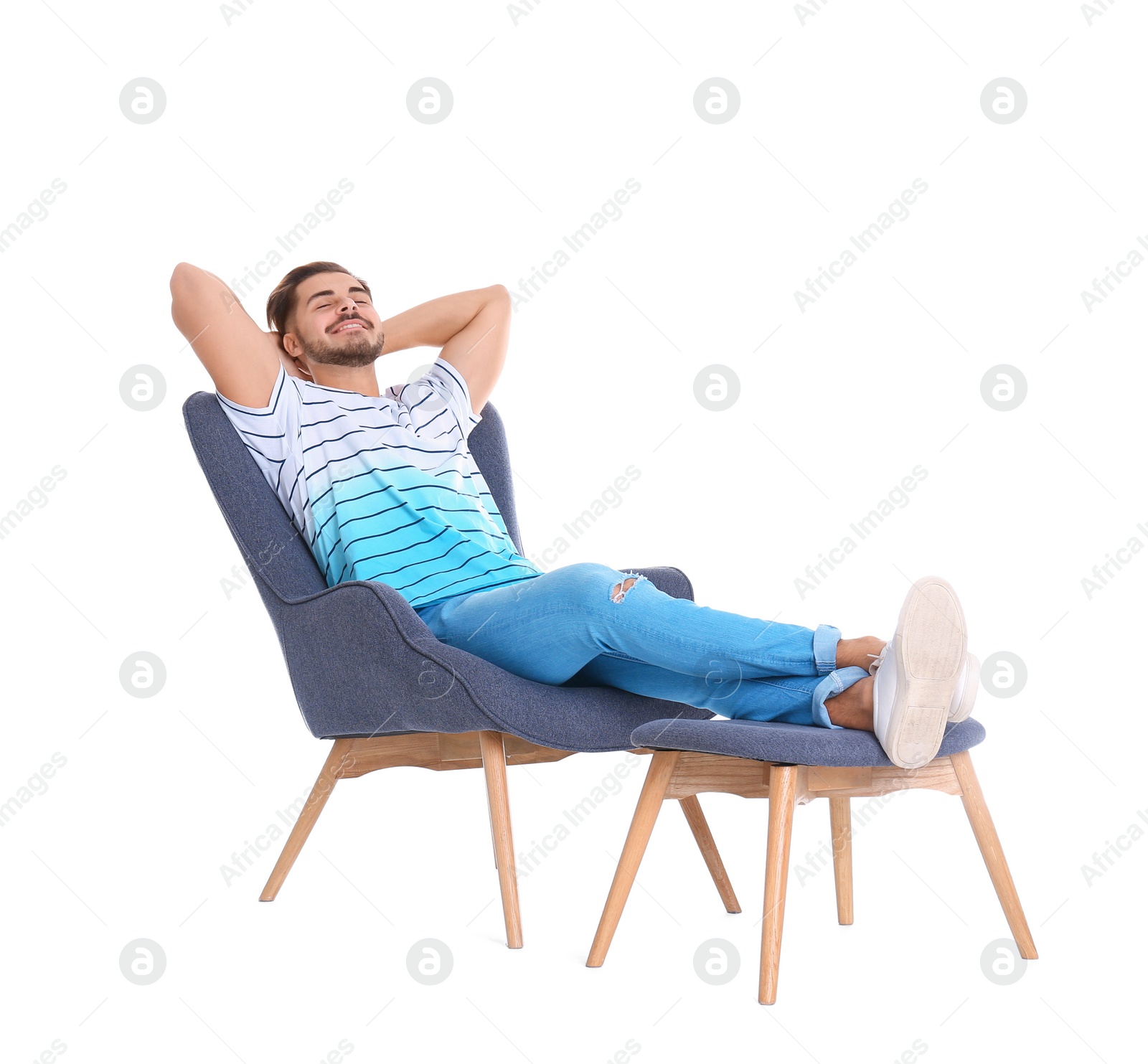 Photo of Handsome young man relaxing in armchair with legs on footrest against white background