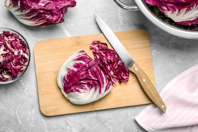 Photo of Whole and cut ripe radicchios on light grey marble table, flat lay