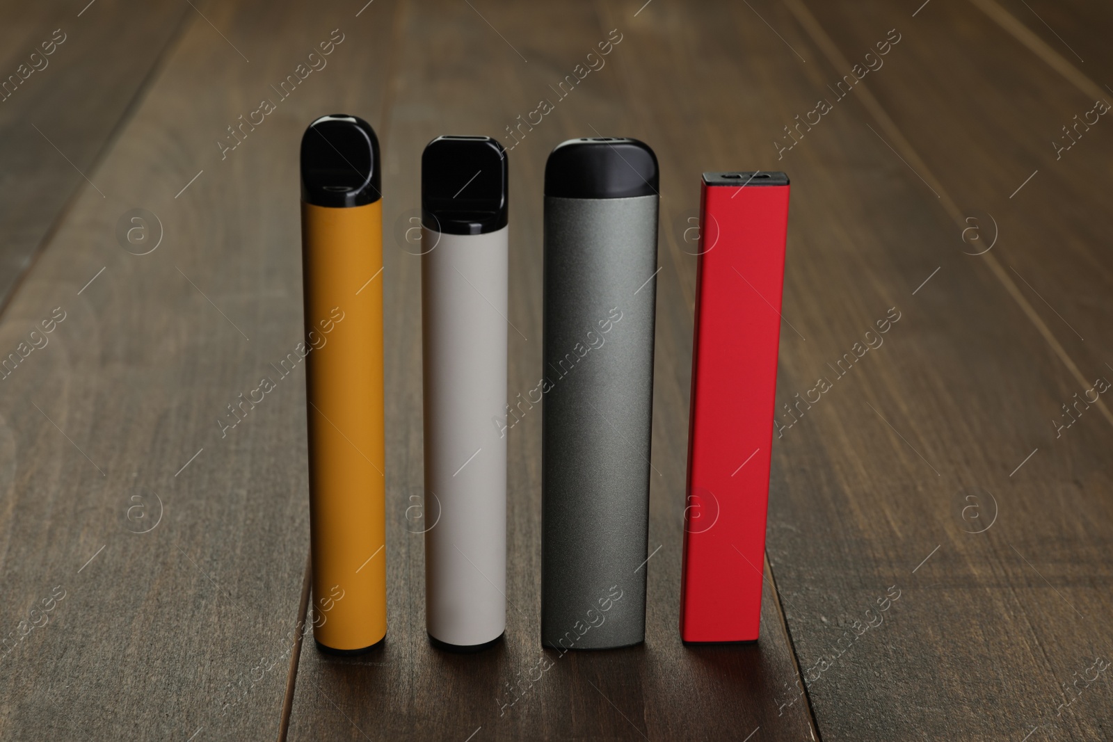 Photo of Many different electronic cigarettes on wooden table