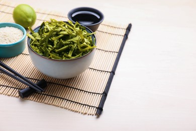 Photo of Fresh laminaria (kelp) seaweed served on wooden table, space for text