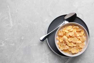 Photo of Tasty cornflakes with milk served on light grey table, top view. Space for text