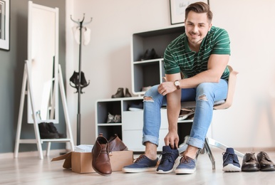 Young man trying on shoes in store