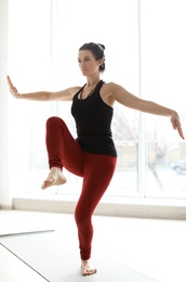 Sporty woman practicing yoga indoors