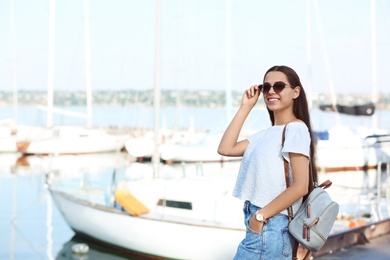 Photo of Young hipster woman in jean skirt on pier