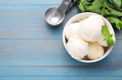 Delicious vanilla ice cream with mint and scoop on light blue wooden table, flat lay. Space for text