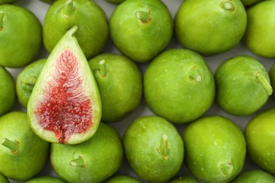 Cut and whole fresh green figs as background, top view