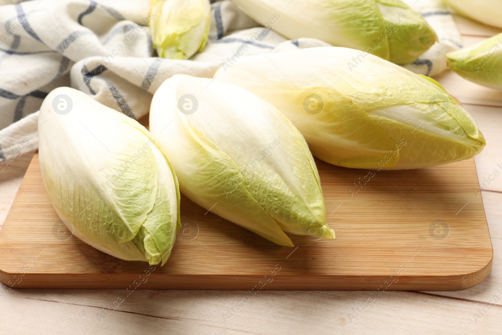 Photo of Raw ripe chicories on wooden table, closeup