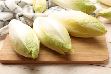 Raw ripe chicories on wooden table, closeup