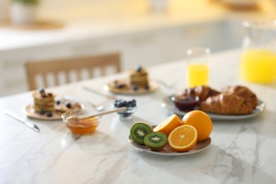 Photo of Tasty breakfast. Plate with kiwi and orange on white marble table, selective focus