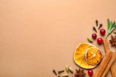 Different mulled wine ingredients on brown background, flat lay. Space for text