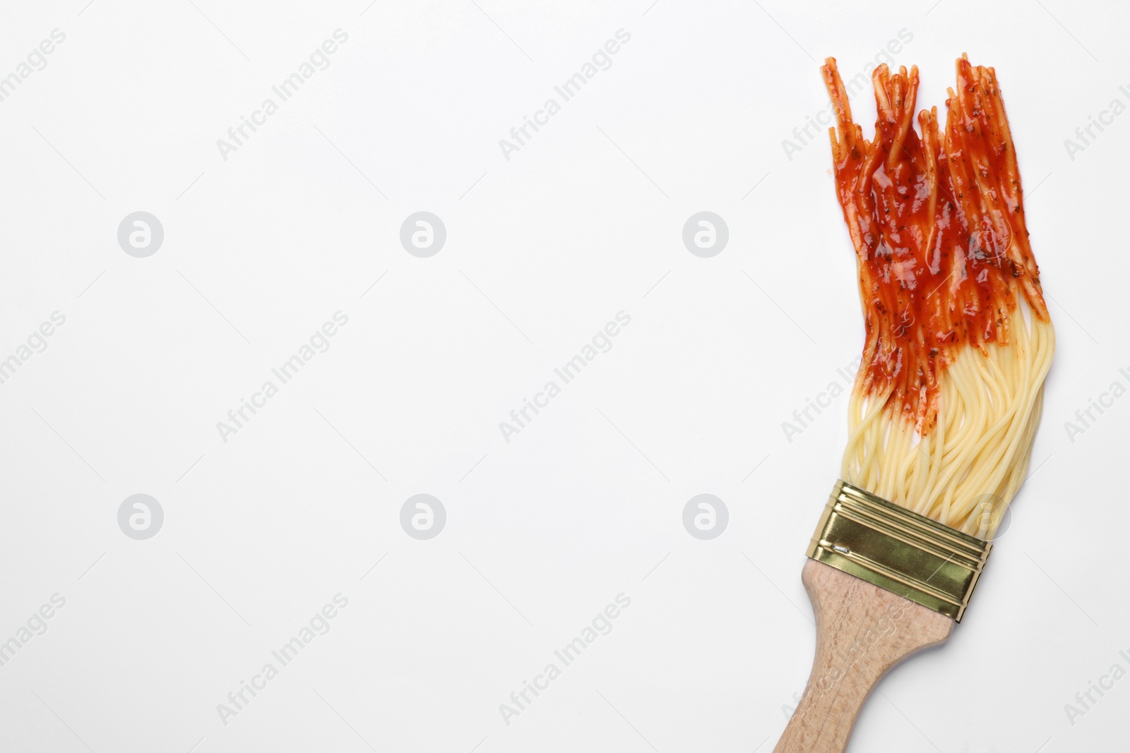 Photo of Brush painting with spaghetti dipped in ketchup on white background, top view. Space for text. Creative concept