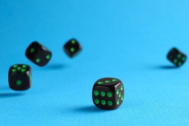 Photo of Many black game dices on light blue background
