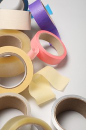Photo of Many rolls of adhesive tape on light background