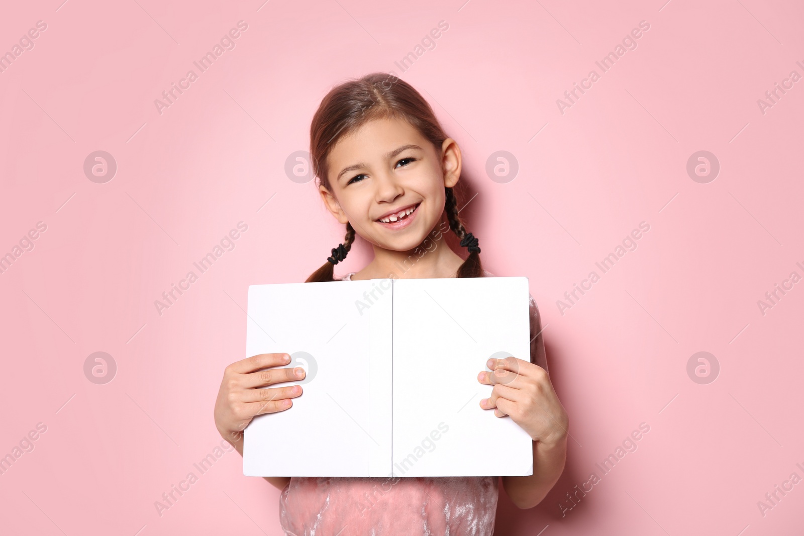 Photo of Cute little girl with book on color background