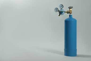 Medical oxygen tank on light grey background. Space for text