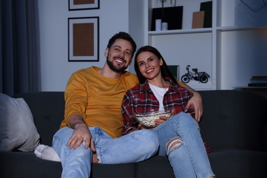 Photo of Happy couple watching TV at home in evening