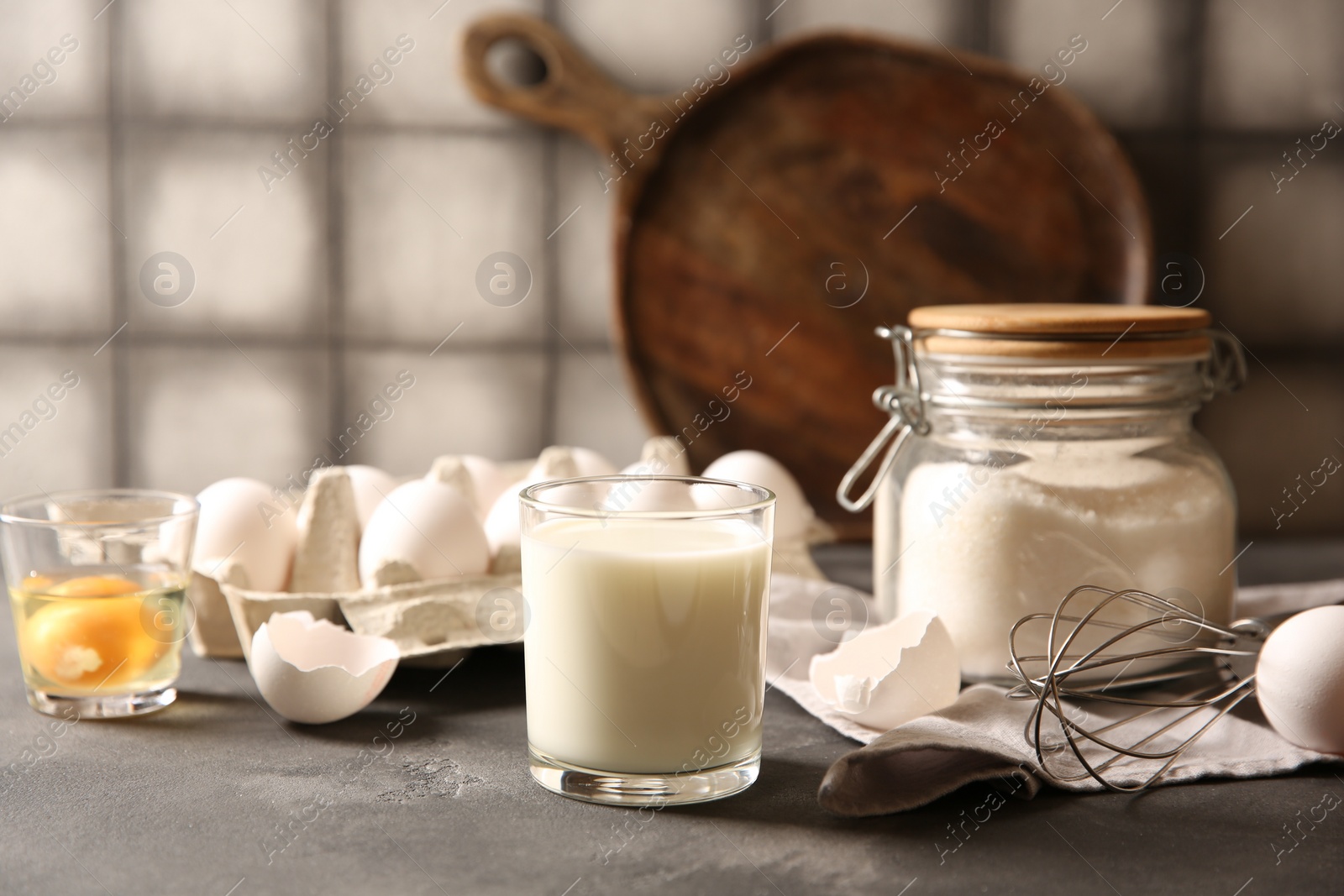 Photo of Different ingredients for dough on grey table, closeup