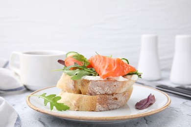 Photo of Tasty bruschetta with salmon, cucumbers and herbs on white textured table, closeup