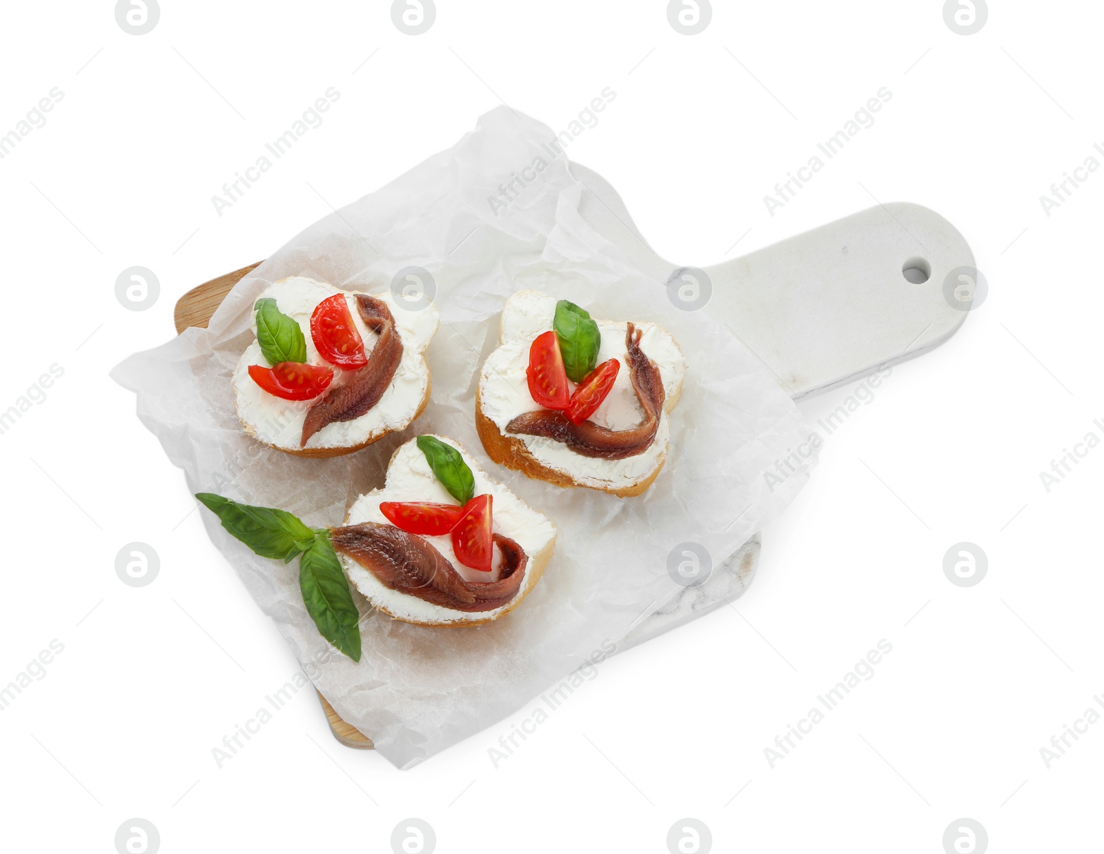 Photo of Delicious sandwiches with cream cheese, anchovies, tomatoes and basil on white background, top view