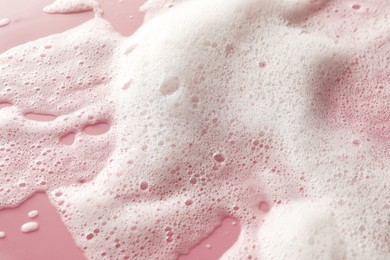 Photo of White washing foam on pale pink background, top view