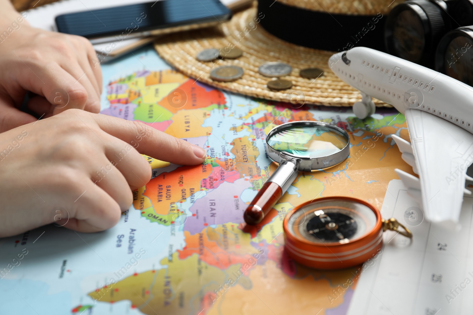 Photo of Woman with world map at table, closeup. Travel during summer vacation