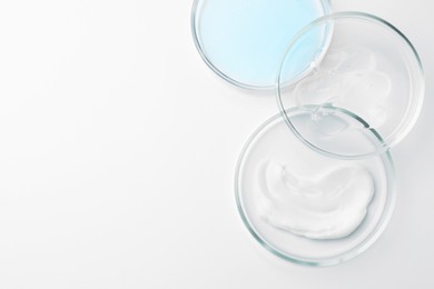 Photo of Many Petri dishes and cosmetic products on white background, top view