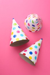 Photo of Beautiful party hats on pink background, top view