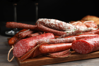 Photo of Different tasty sausages on wooden table, closeup