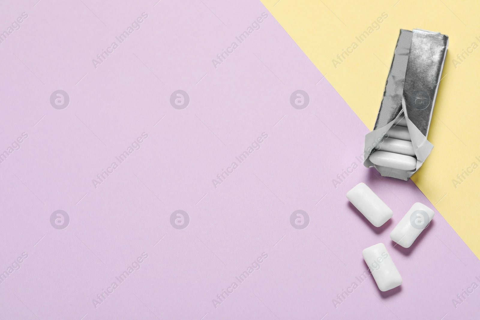 Photo of Pack with tasty chewing gums on color background, flat lay. Space for text