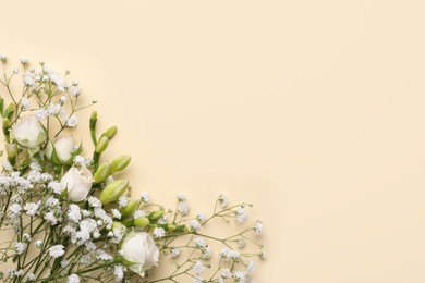 Beautiful gypsophila, roses and freesia flowers on beige background, top view. Space for text