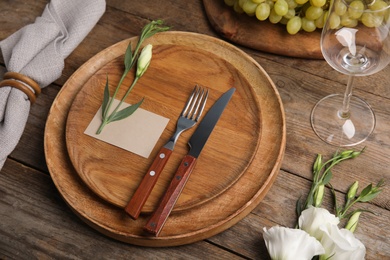 Elegant festive table setting with blank card on wooden background