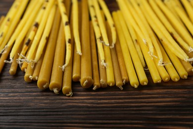 Many church candles on wooden table, closeup
