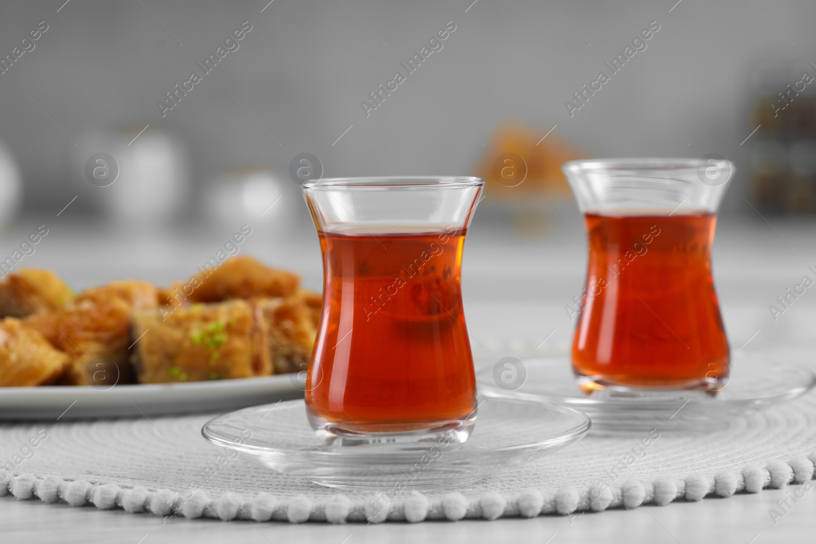 Photo of Glasses of traditional Turkish tea on white table indoors