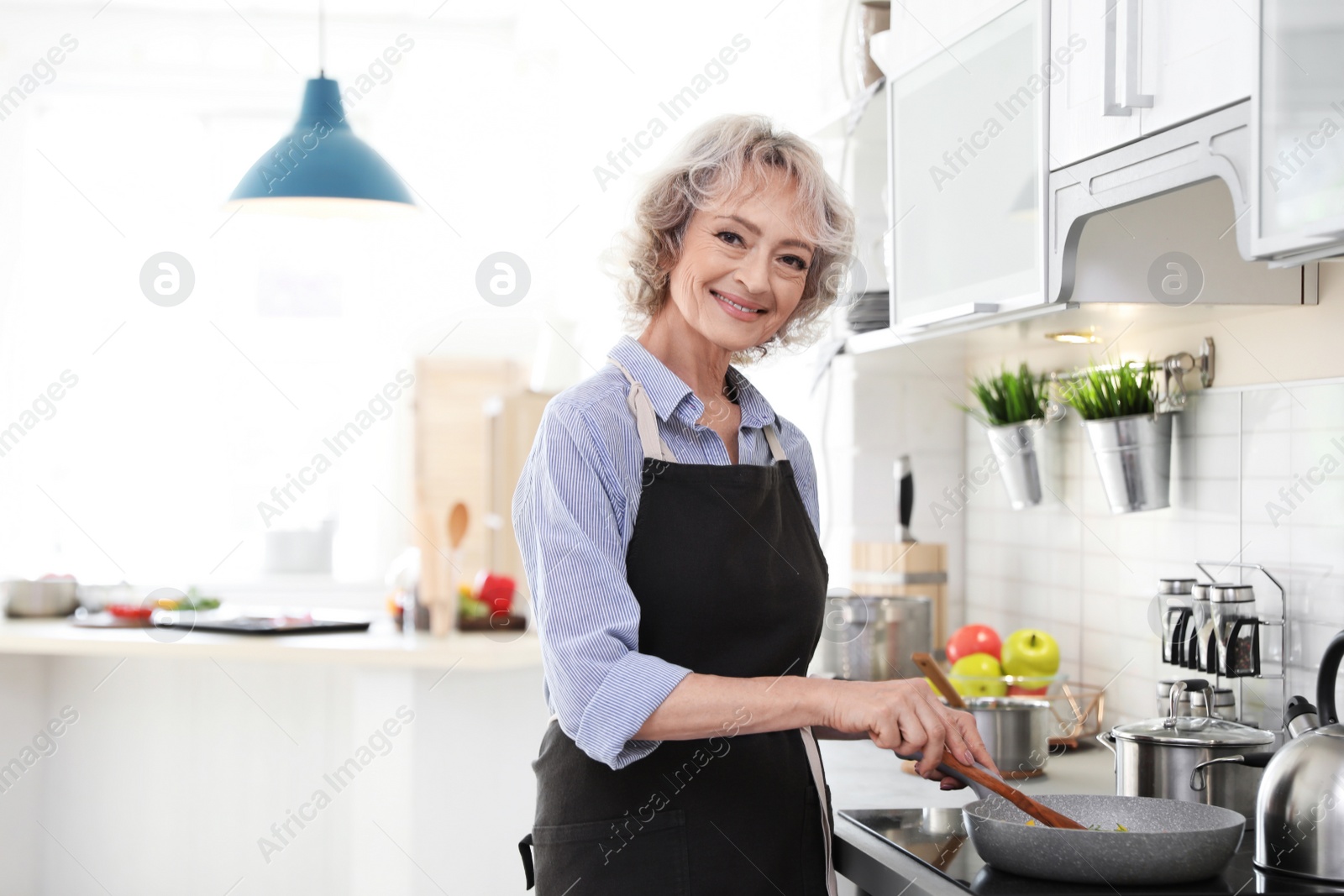 Photo of Professional female chef cooking vegetables in kitchen