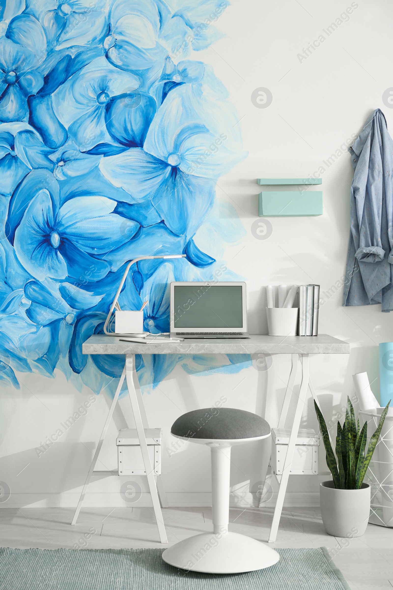 Photo of Stylish living room interior with blue flowers painted on wall. Floral pattern