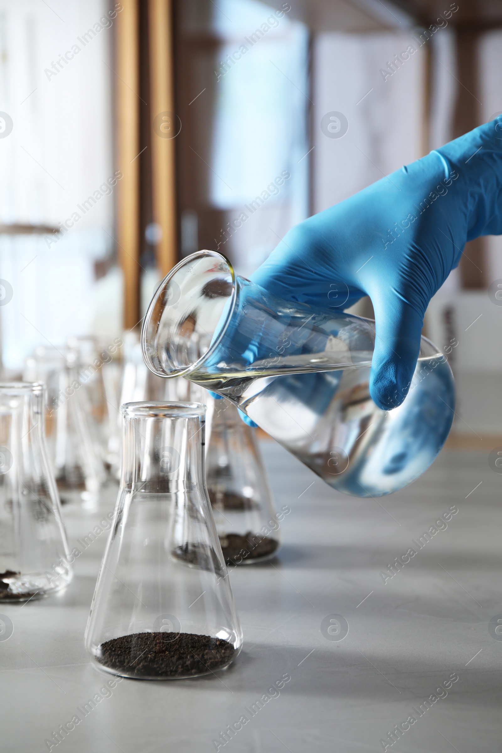 Photo of Scientist preparing soil extract at table, closeup. Laboratory research