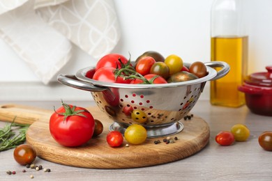 Photo of Metal colander with fresh tomatoes on wooden table