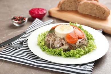 Photo of Delicious aspic with meat and vegetables served on grey table