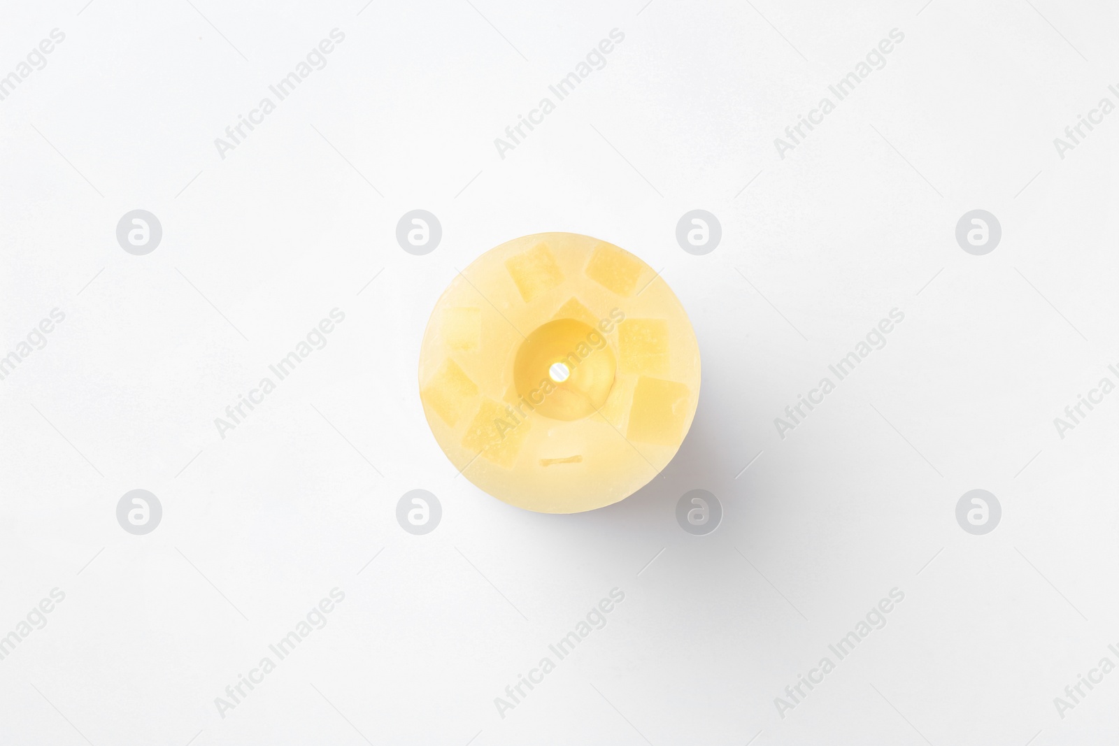 Photo of Yellow candle isolated on white, top view