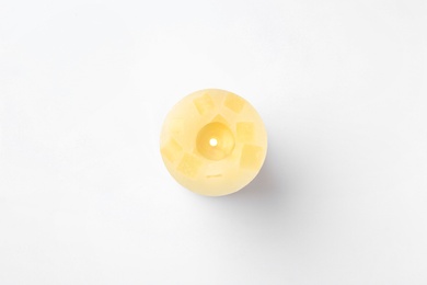 Yellow candle isolated on white, top view