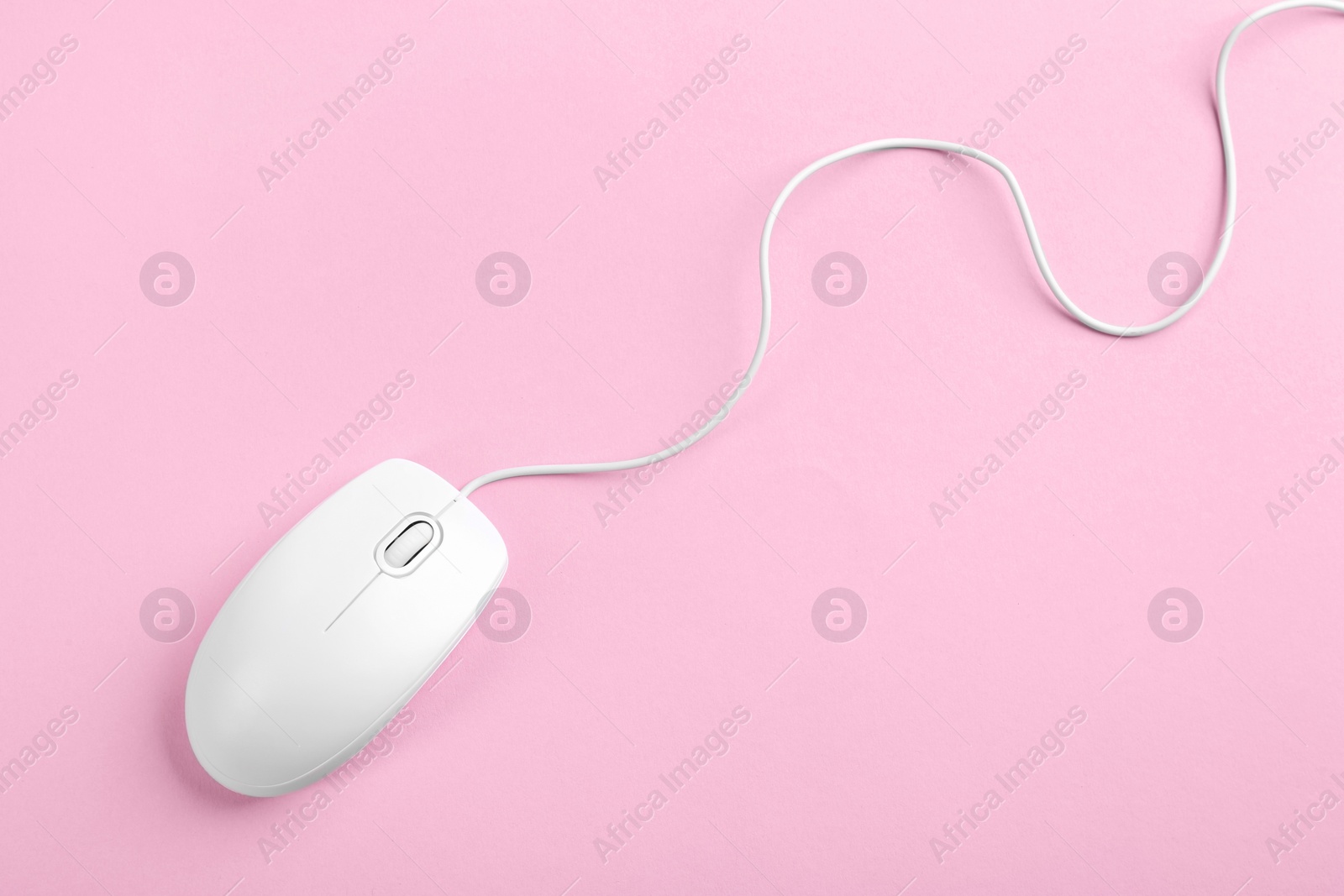 Photo of Modern wired optical mouse on pink background, top view