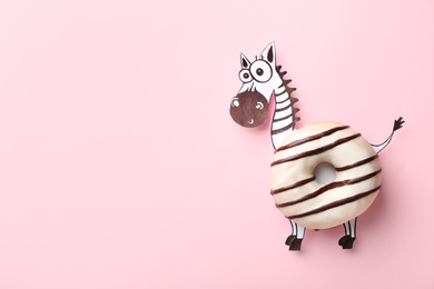 Photo of Funny zebra made with donut and piece of paper on pink background, top view. Space for text