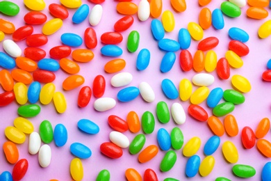 Photo of Colorful jelly beans on lilac background, flat lay