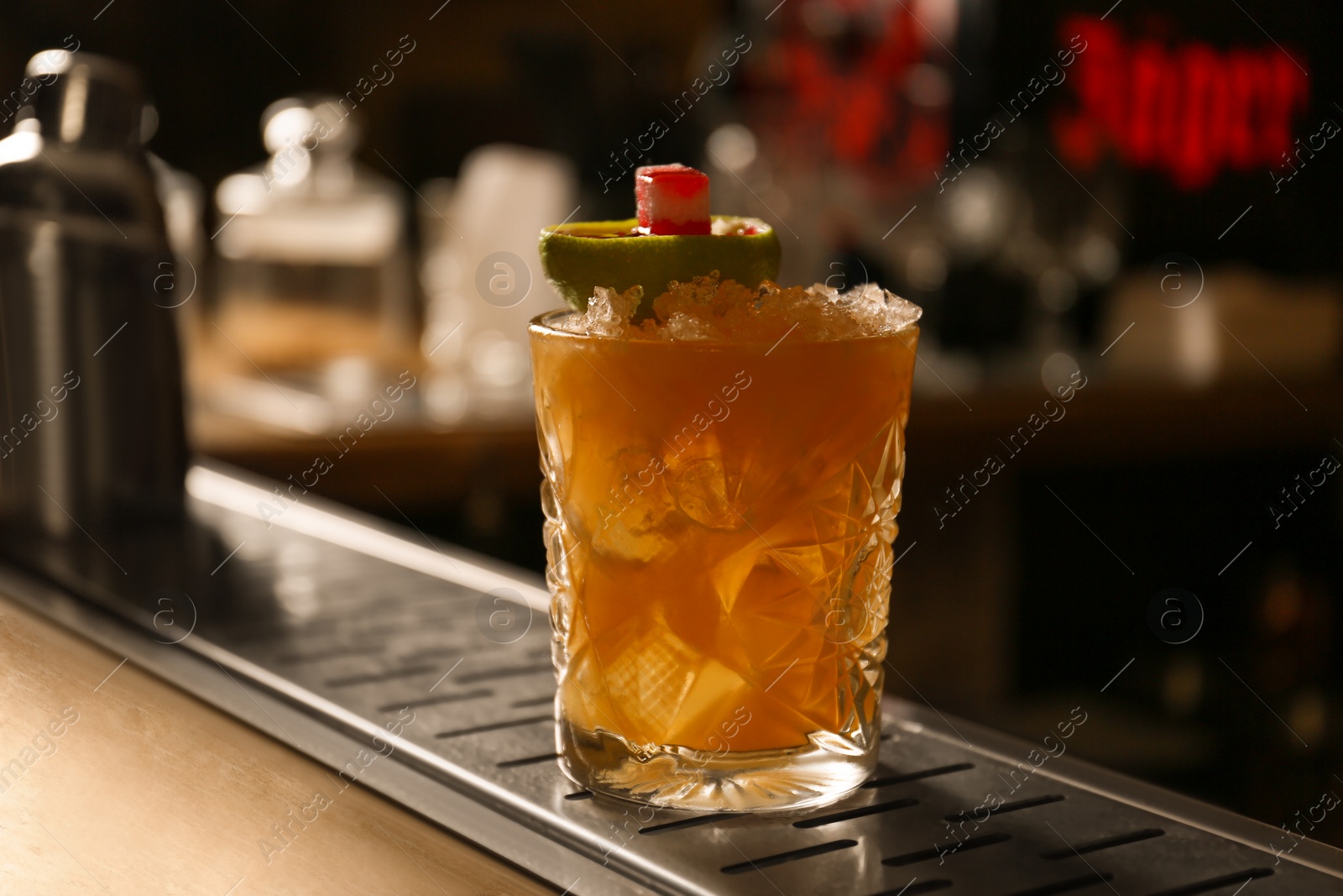 Photo of Glass of fresh alcoholic cocktail at bar counter, closeup