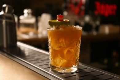Glass of fresh alcoholic cocktail at bar counter, closeup