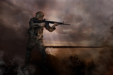 Image of Soldier with weapon on battlefield. Military service