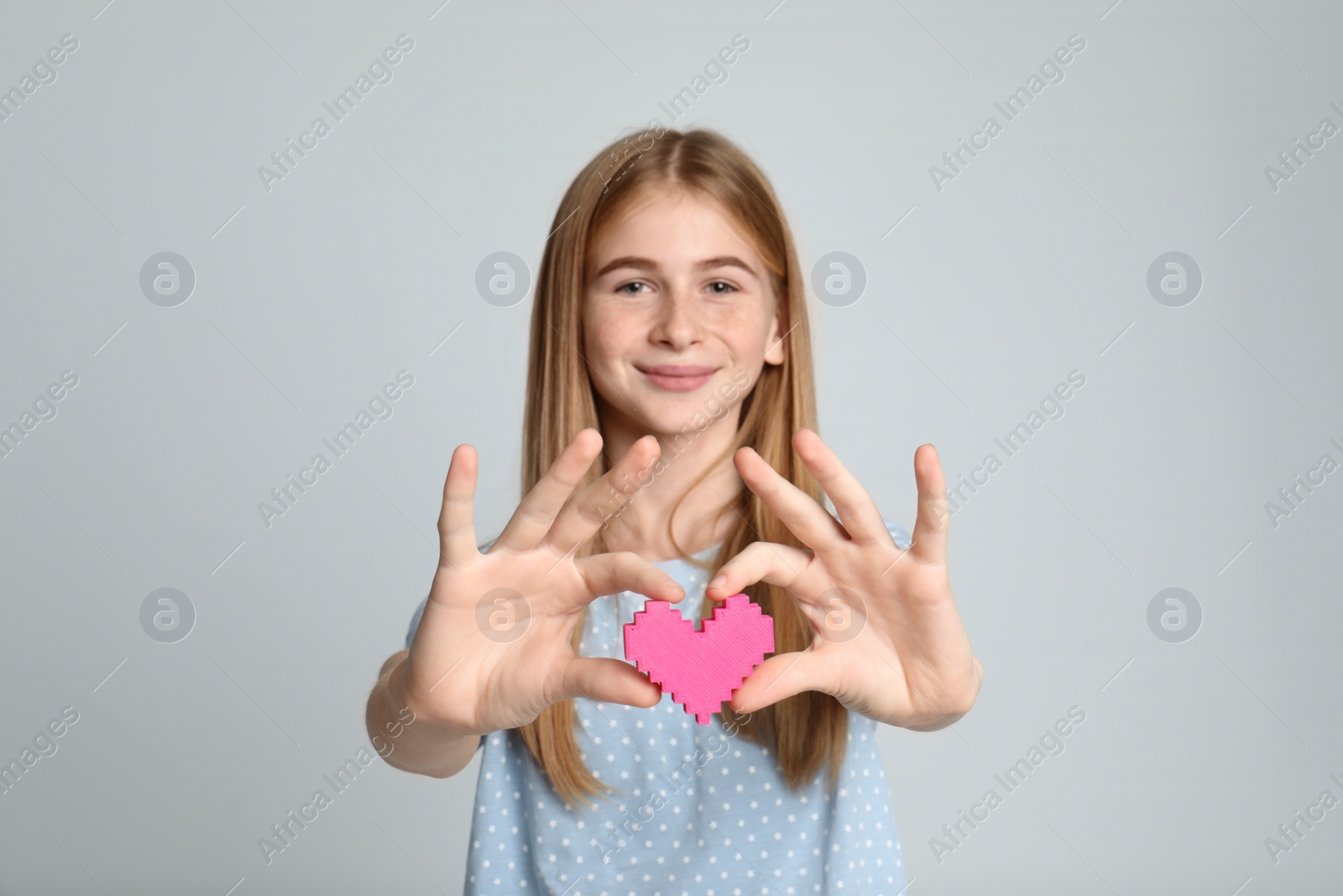 Photo of Pretty teenage girl with decorative heart on color background