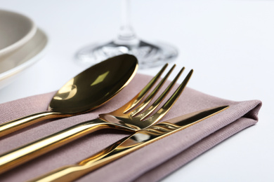 Photo of Stylish elegant cutlery set with napkin on white table, closeup
