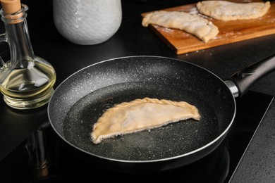 Cooking chebureki with tasty filling in frying pan